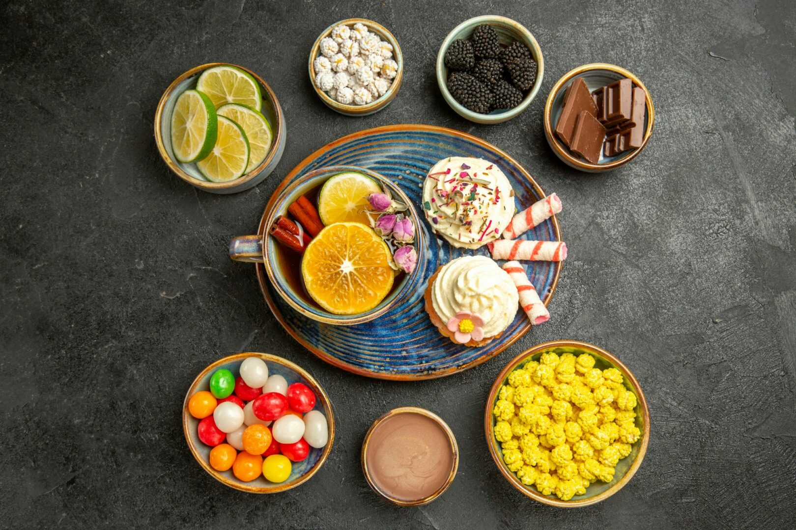 top view from afar sweets on the table bowls of different berries chocolate citrus fruits colorful